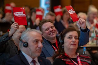 Teilnehmer*innen der DGB-Bezirkskonferenz Sachsen mit roter Karte gegen Kahlschlag in der Hand.