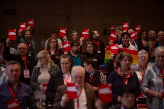 Teilnehmer*innen der DGB-Bezirkskonferenz mit roter Karte gegen Kahlschlag in der Hand.